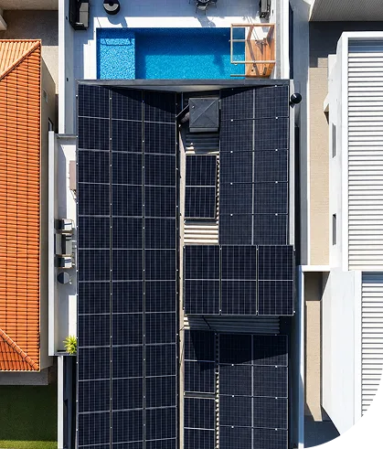 Vista aérea de painéis solares no telhado de uma residência com piscina