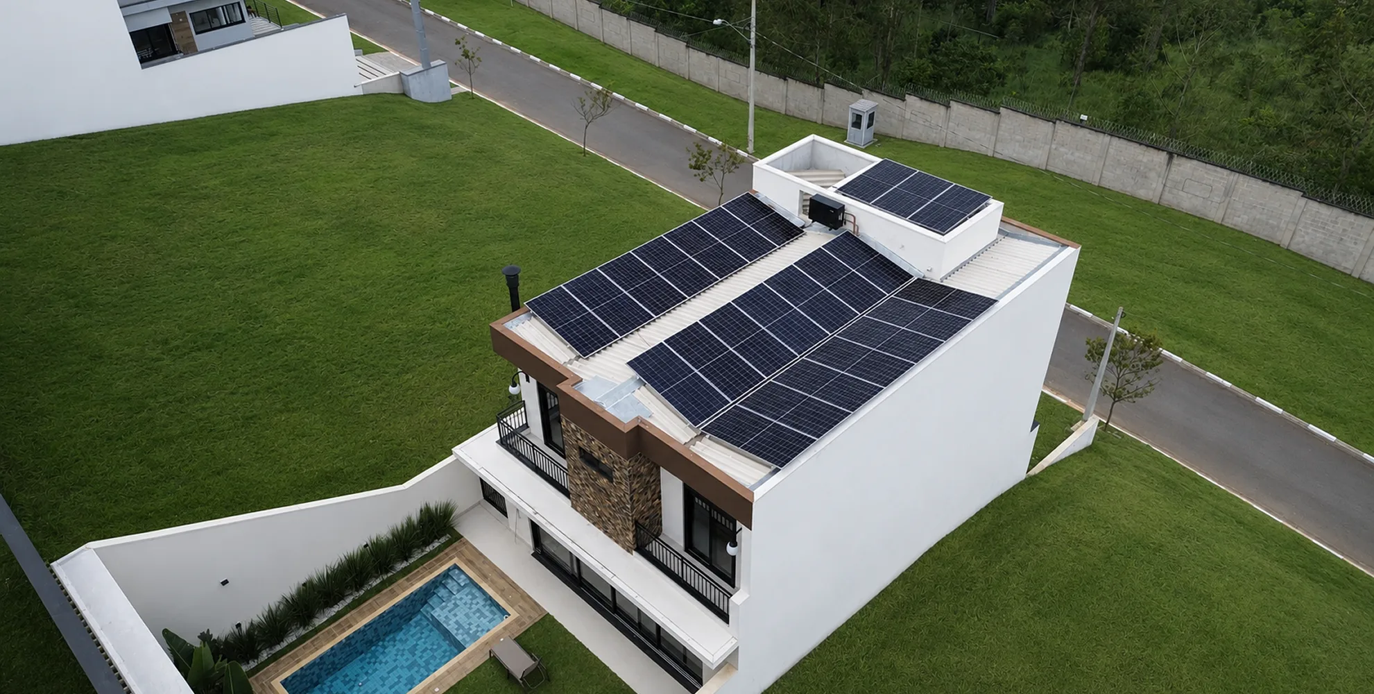 Vista aérea de residência de dois pavimentos com painéis solares instalados no telhado metálico