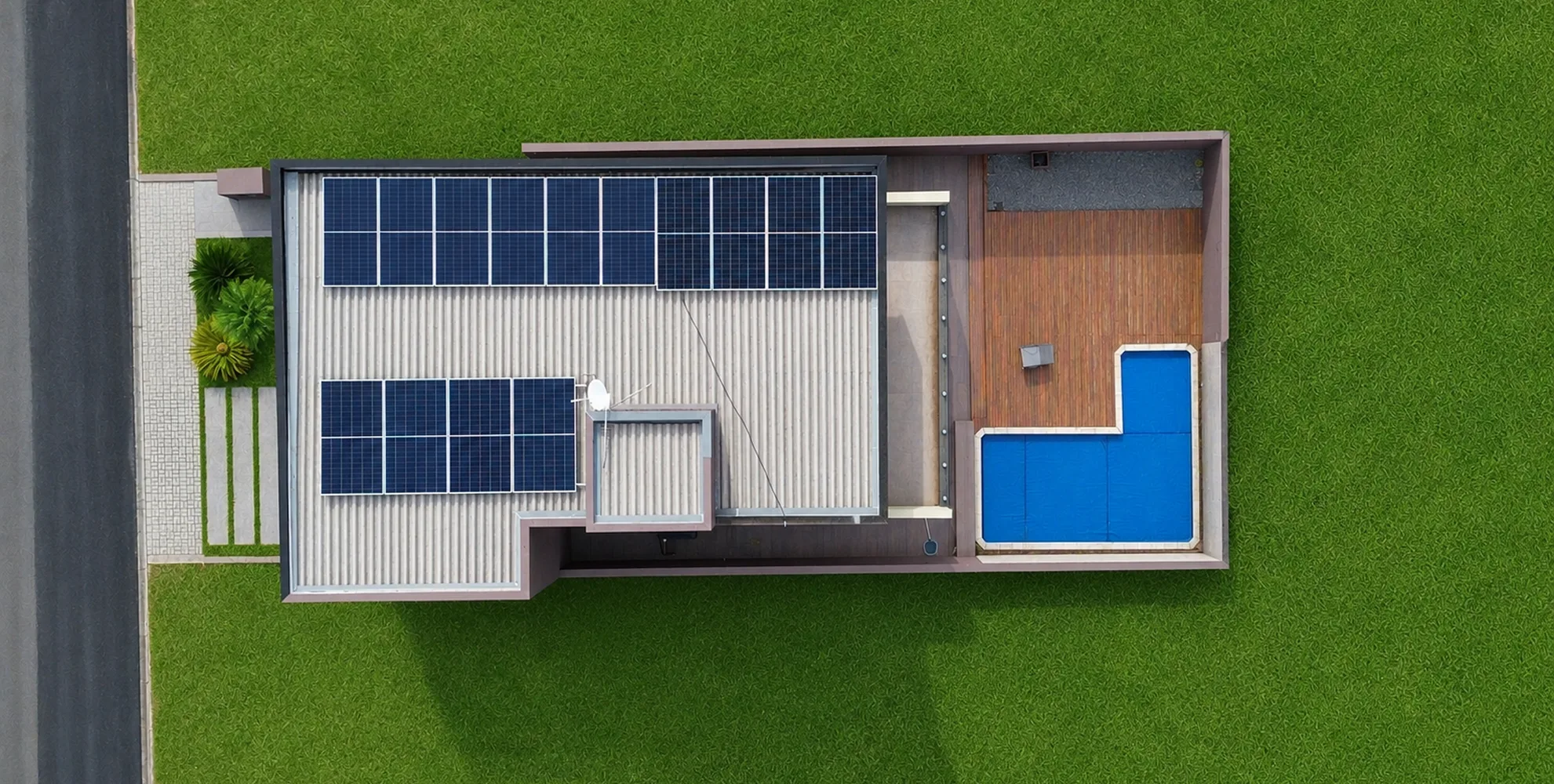 Vista superior de residência com dois conjuntos de painéis solares no telhado e área de lazer com piscina